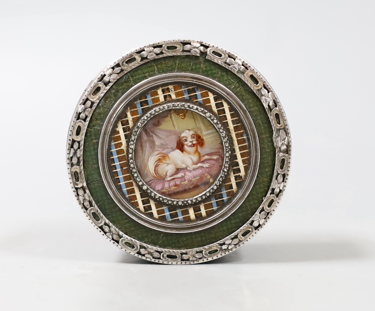 A 19th century King Charles Spaniel miniature inset into a leather and silver mounted tortoiseshell interior box. 6.5cm diameter